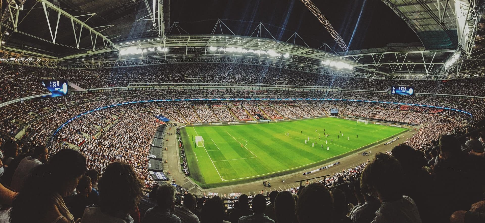 A packed football stadium under the floodlights